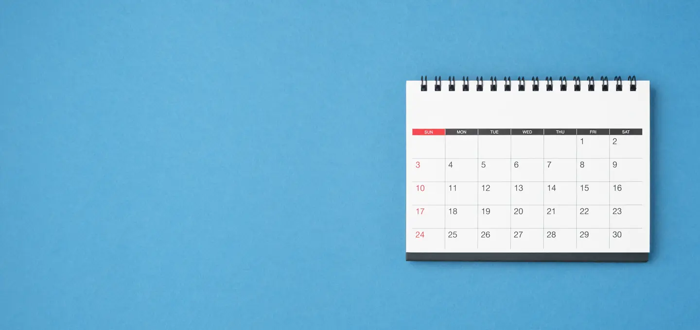 Tischkalender mit Monatsübersicht auf blauem Hintergrund