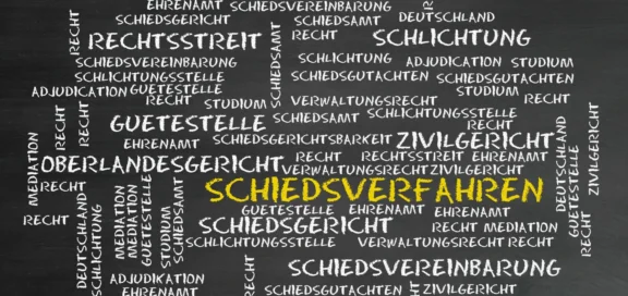 Tafel mit juristischen Begriffen rund um das Thema Streitbeilegung, wie „Schiedsverfahren“ (hervorgehoben in Gelb), „Oberlandesgericht“, „Zivilgericht“, „Rechtsstreit“, „Schlichtung“, „Mediation“, „Schiedsgericht“, „Recht“ und weiteren verwandten Wörtern in weißer Kreideoptik.
