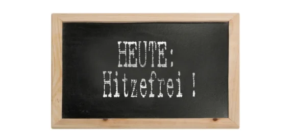 Schultafel mit dem weißen Schriftzug ‚HEUTE: Hitzefrei!‘, umgeben von einem Holzrahmen.“