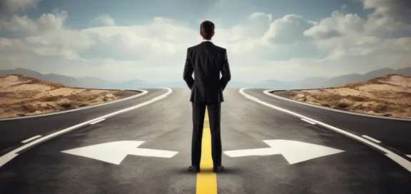 Geschäftsmann steht vor zwei Weggabelungen als Symbol für strategische Entscheidungen und rechtliche Weichenstellungen im Commercial Court Verfahren.