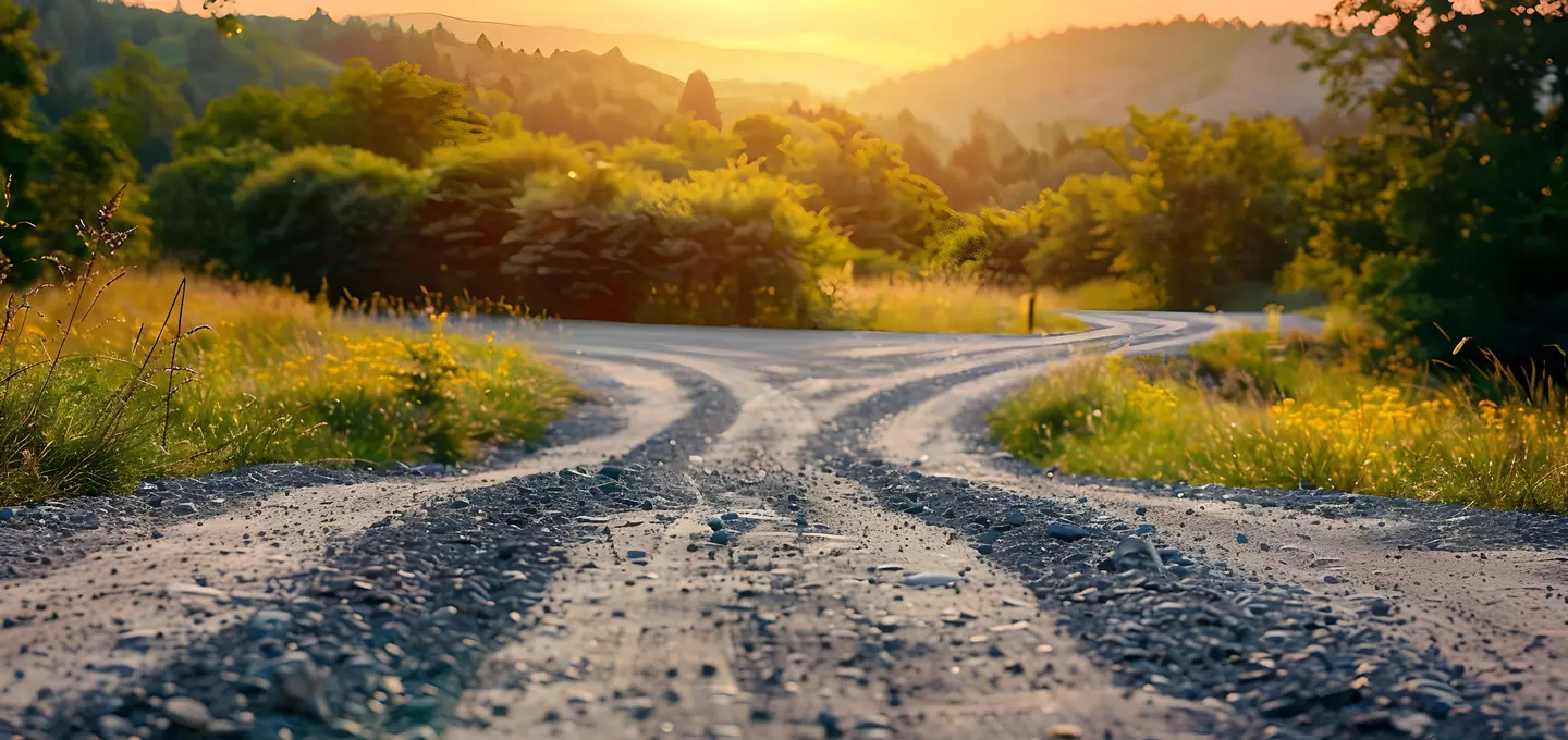 Ein Schotterweg, der sich im Abendlicht teilt, symbolisiert die Wahl zwischen Konflikt und Einigung – ein Bild, das den Sinn einer Streitschlichtungsklausel verdeutlicht.